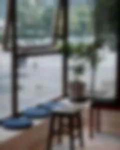 형태만 알아볼 수 있게 연하게 흐려진 창가 사진 위에 자물쇠 아이콘이 놓여 있다